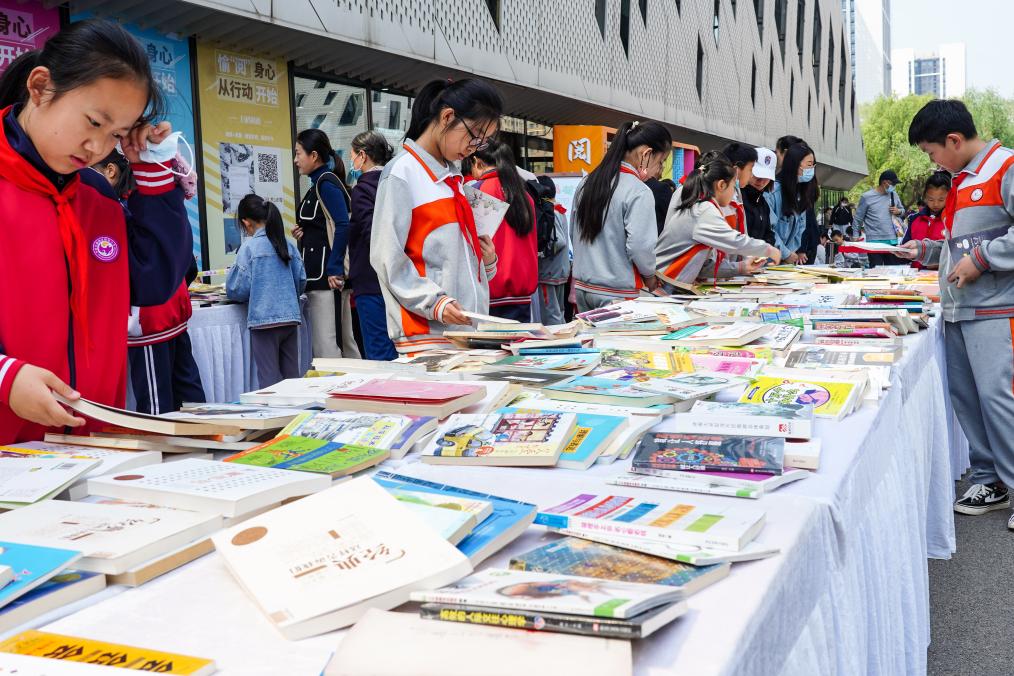4月20日，山东省济南市第十四届“书香泉城”全民阅读节在济南市图书馆启动，小员工在阅读节上参与换书活动。新华社记者 朱峥 摄